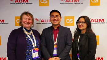 Three people standing smiling at the conference