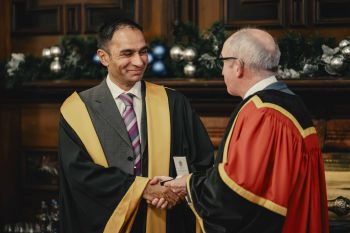 Mood Bhutta in formal attire holding his Royal College President's Medal