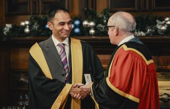 Mood Bhutta in formal attire holding his Royal College President's Medal