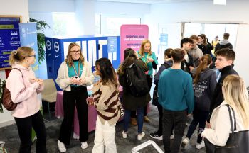 University of Sussex careers fair showing students talking in front of a publicity stand