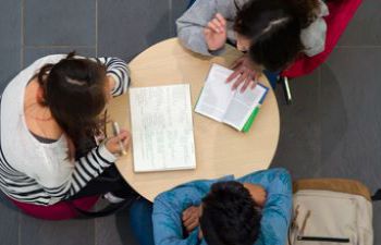 Three students sitting at a round table