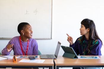 Two students talking in a classroom