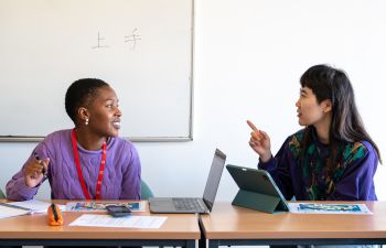 Two students talking in a classroom