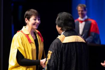 Caroline Lucas shakes Sanjeev Bhaskar's hand at winter graduation