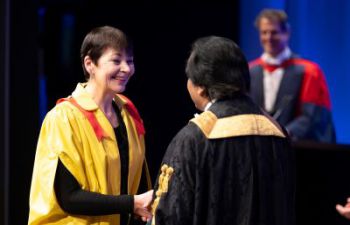 Caroline Lucas shakes Sanjeev Bhaskar's hand at winter graduation