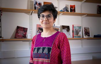 headshot of dr gunjan wadhwa smiling in front of a bookshelf