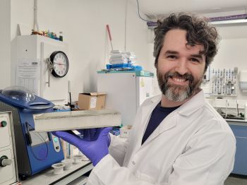 scientist holding block of material used to build wind turbine blades