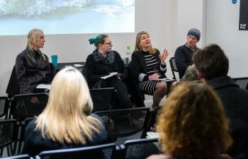 Four panellists sitting in front of an audience