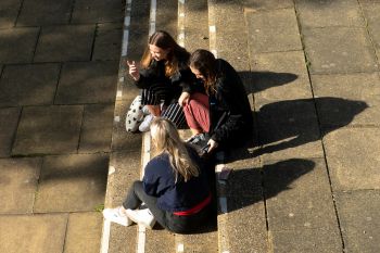 Students photographed from above sitting on a set of outdoor steps on campus