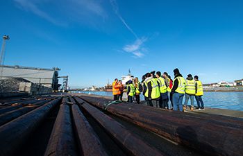 Group of students in high-vis jackets standing next to the water at Shoreham Port