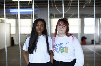 photo of two people standing next to each other looking into the camera in white tshirts