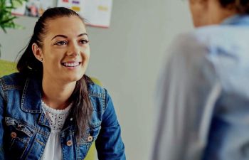 Course image of a woman speaking to a man in an office setting.