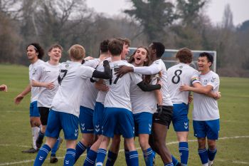 an image of a football team celebrating in a group huddle