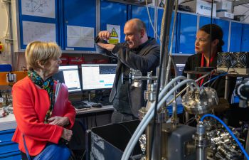 Baroness Jones and Bella Sankey are shown around the quantum lab by Professor Winfried Hensinger