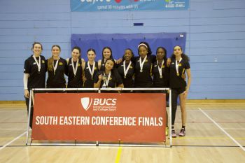 a women basketball team posing with their trophy