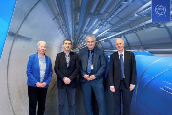 A picture of four individuals smiling at the camera, including Professor Michael Luck, Professor Luc Moreau and Joachim Mnich