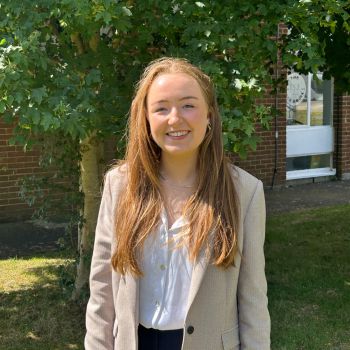 Maighsi stood on a sunny day in front of a Sussex building