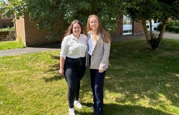 2 Sustainability interns stood together on a sunny day