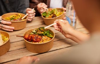 A delicious looking healthy bowl of food that includes chicken skewers and broccoli