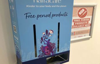 A photo of a Natracare free period product dispenser, mounted on the wall