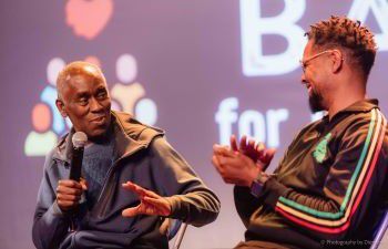 Alex Wheatle and Bud Johnston sitting next to each other on stage