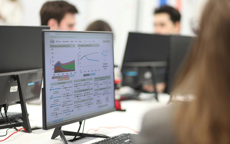 A computer on a desk showing graphs on the screen