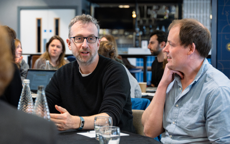 Staff sitting at a table and chatting at a networking event