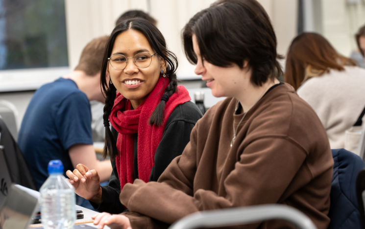 Student smiling with a friend at a seminar