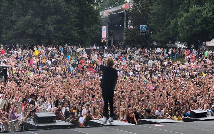 A performer in front of crowd at an outdoor event