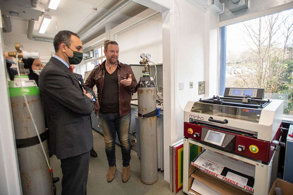 Two men look at lab equipment