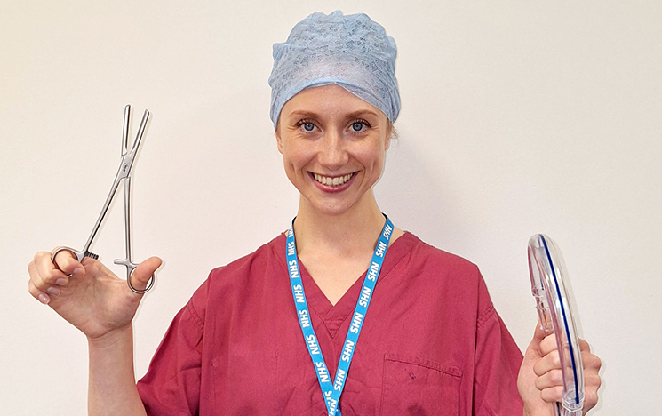 A woman in medical scrubs holding medical equipment