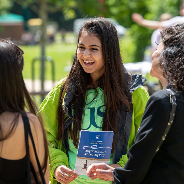 Student talking to visitors on campus