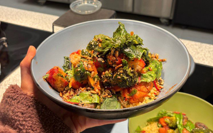 Hand holding a vegetarian meal in a bowl
