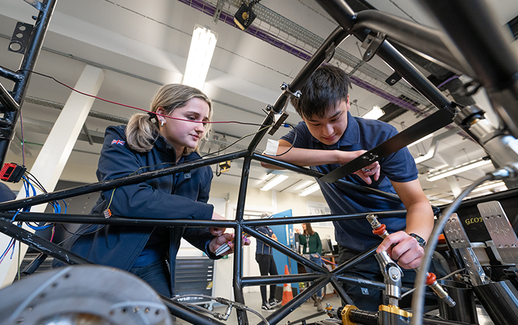 Students looking at equipment in the formula student workshop