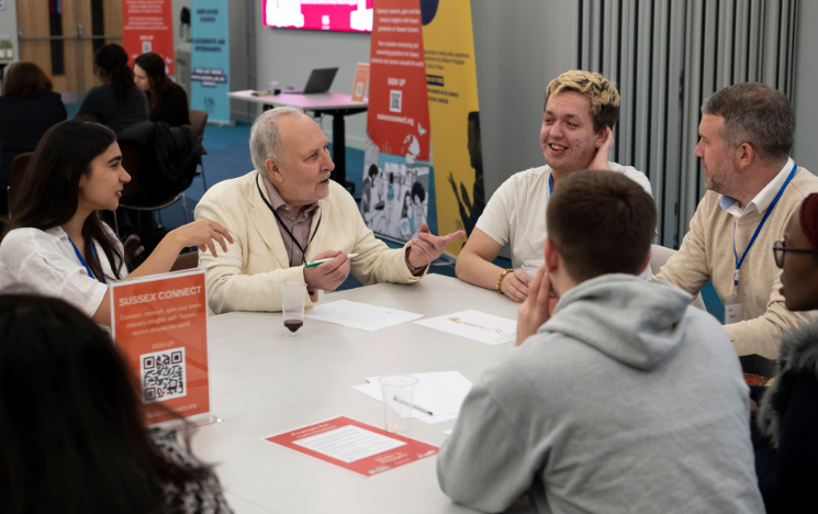 Students and alumni having discussions around a table in the Student Centre.