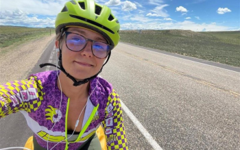 A selfie of Sarah Osborn cycling on the road in the US during their challenge.