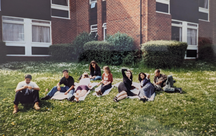 Mo Kanjilal lying on the grass with friends at Sussex in the 1990s.