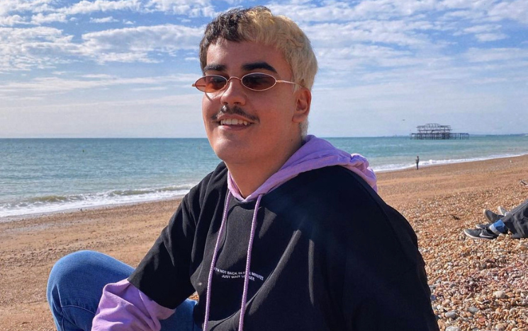 Pablo Santana sat on Brighton Beach, wearing a hooded sweatshirt and sunglasses.