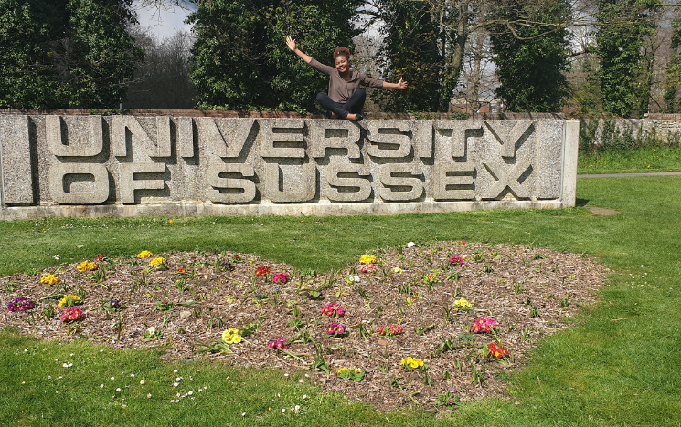 Sarah Egbo sat on one of the University of Sussex concrete signs during her time at Sussex.