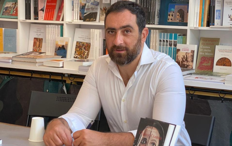 Fadi Zaghmout seated at desk with his book The Bride of Amman