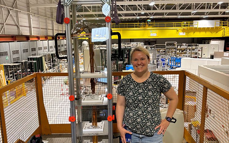 April Cridland stands next to the Penning trap she built for the ALPHA-g experiment