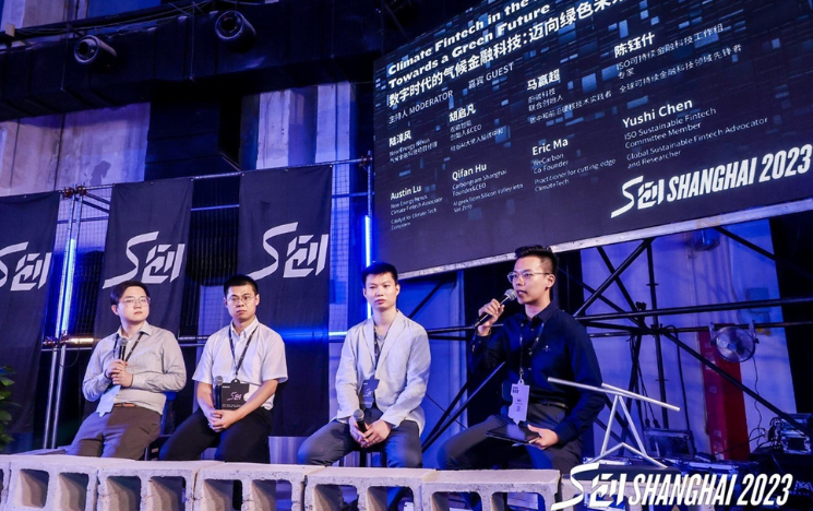 Dr Yushi Chen sat on a stool as part of a panel with three other people at an event focused on climate Fintech in Shanghai.