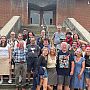 A group of alumni from the mountaineering club gathered on the steps of campus library