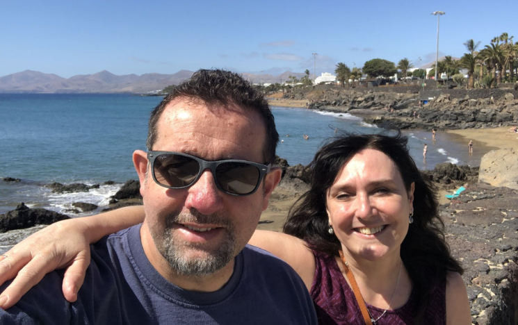 Photo of couple Elaine and Steve with the arms around each other at the beach.