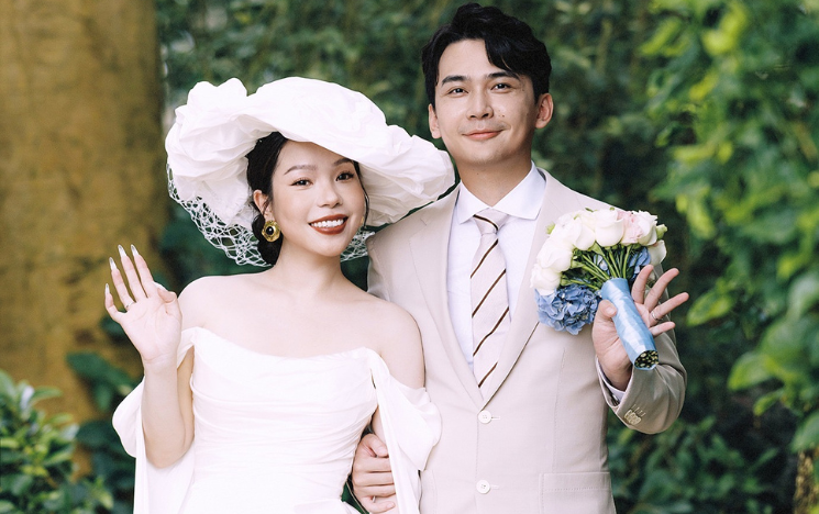 Candice and Yifan on their wedding day waving at the camera.