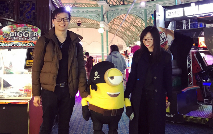 Yangyang Pu and YuChang Hsieh at the arcade with a giant Minion pirate plush toy.