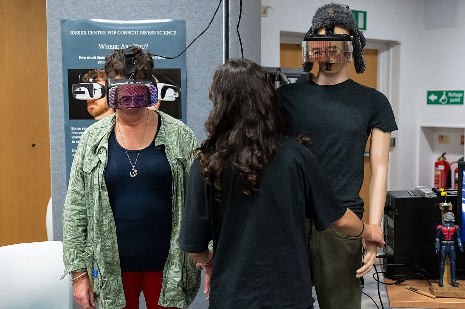 One person wearing a VR headset standing next to a mannequin as part of a body swap illusion.