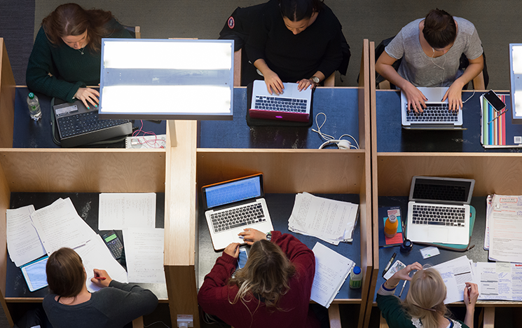 Students working from laptops in the library