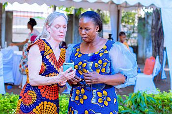 Sarah Stephens showing her digital legal assistant on a mobile to another woman.