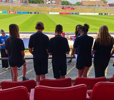 Poet Erin James chanting with young people from Priory School at Lewes FC